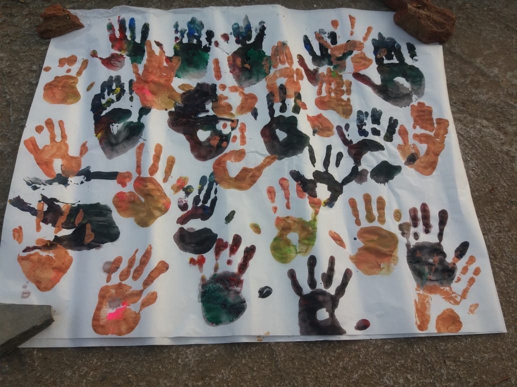 Children's clay creations arranged outdoors, including recognisable handmade forms
