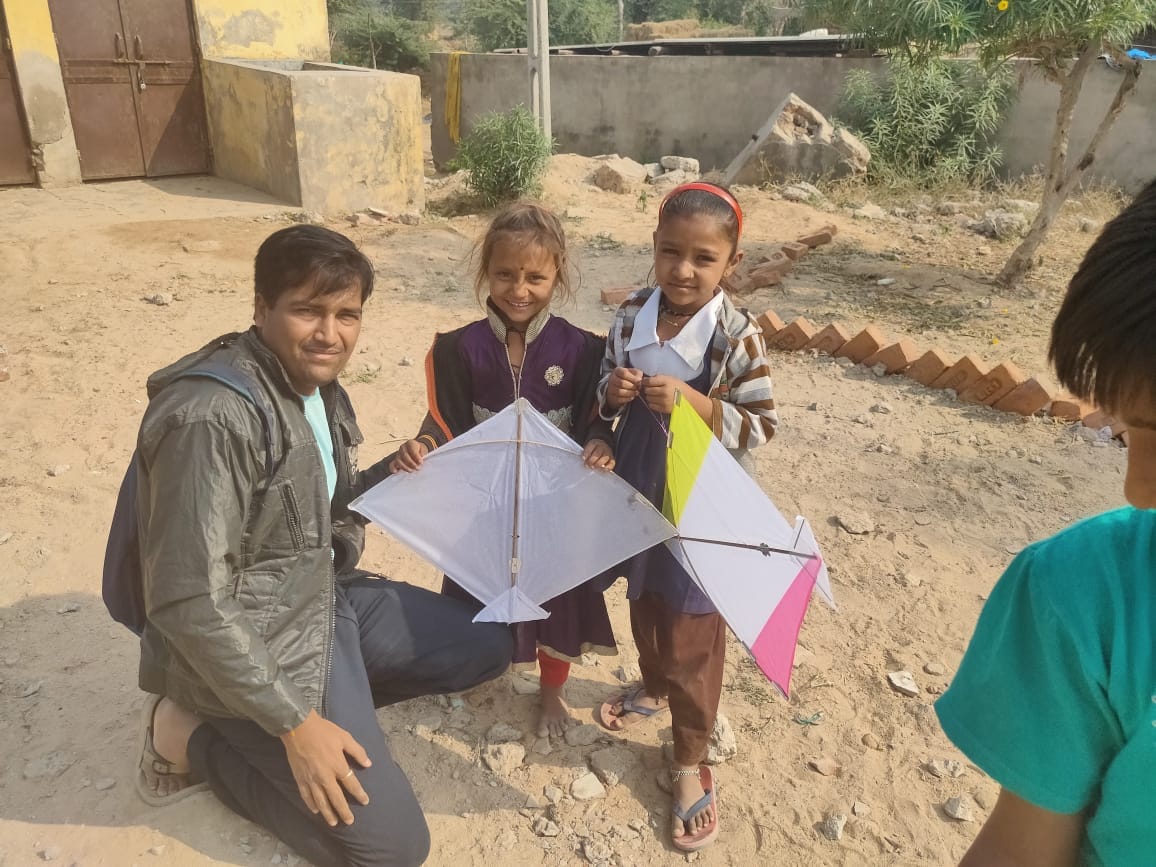 Volunteer with two children holding handmade kites