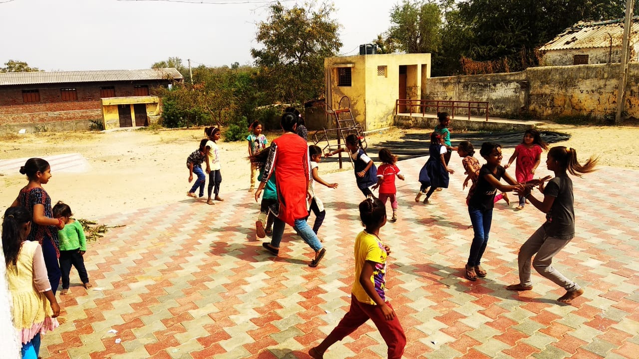 Large group of children and volunteers engaged in an outdoor group game