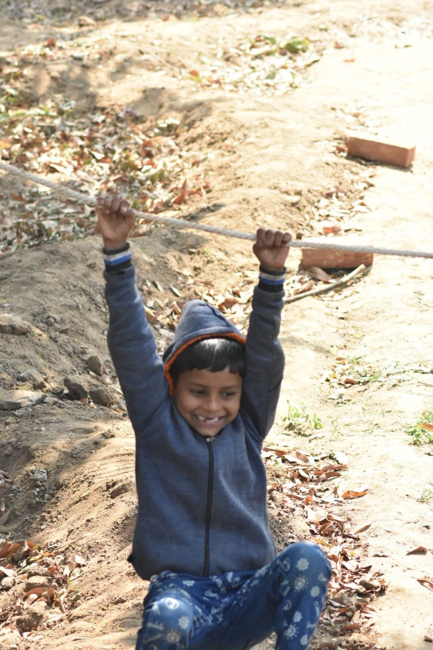 Child hanging from a rope, smiling