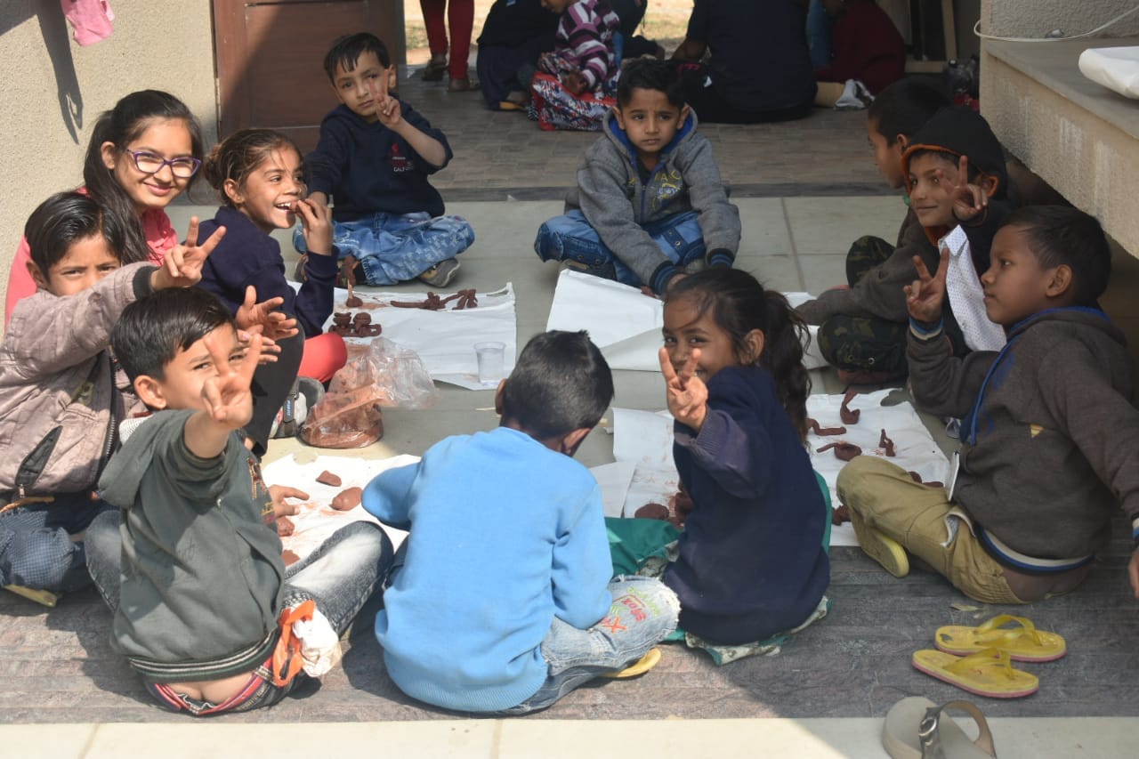 Children sitting together doing hands-on clay/creative work