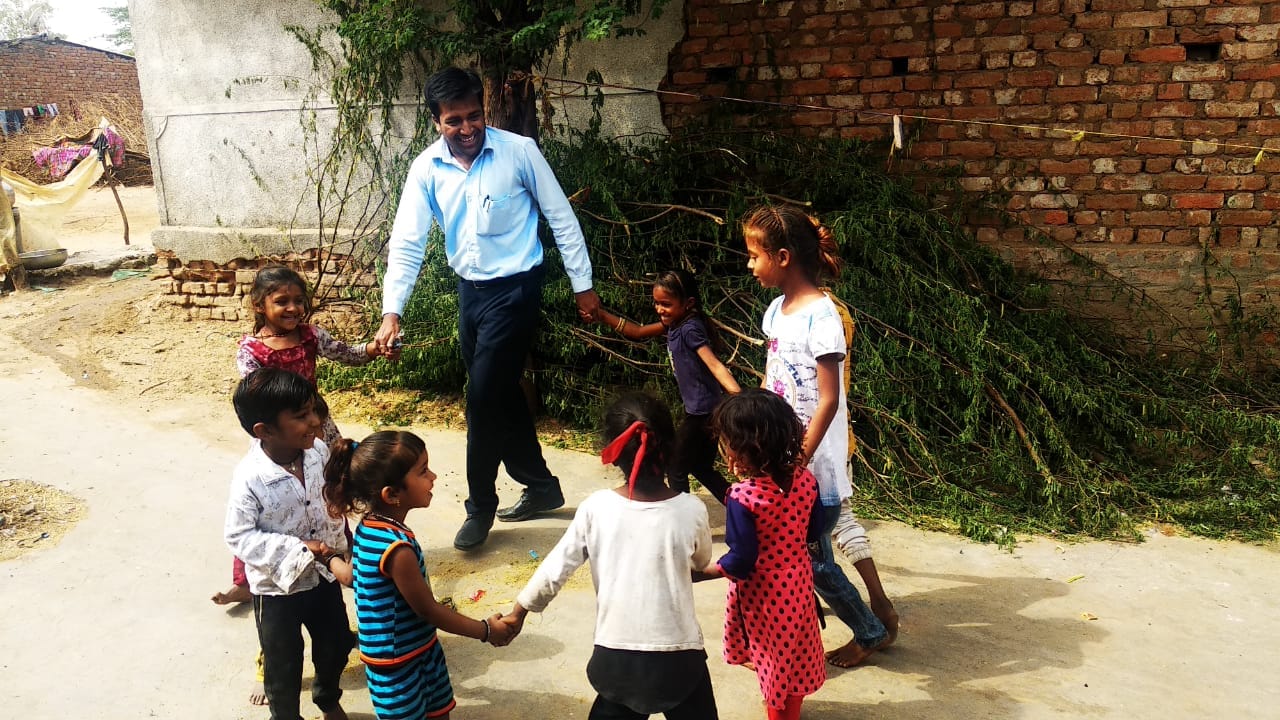 Adult volunteer playing/participating in a circle game with children