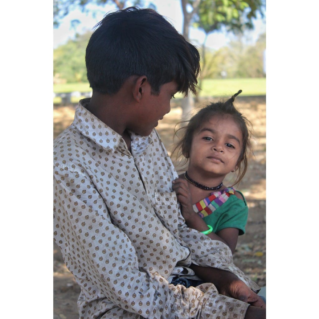 Older boy holding a younger child; both comfortable and connected
