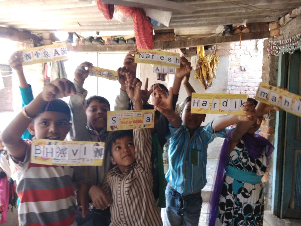 Children proudly hold their handmade name and word cards.