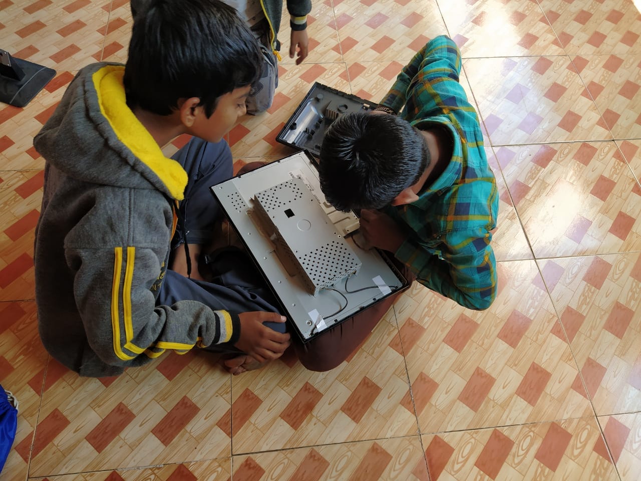 Two children opening and examining computer hardware