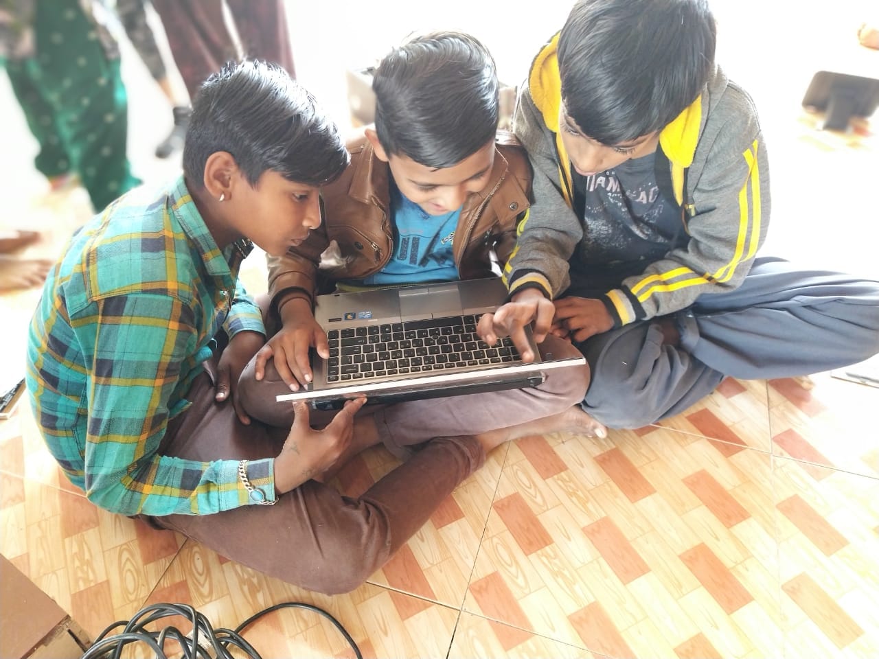 Three children working together on a laptop